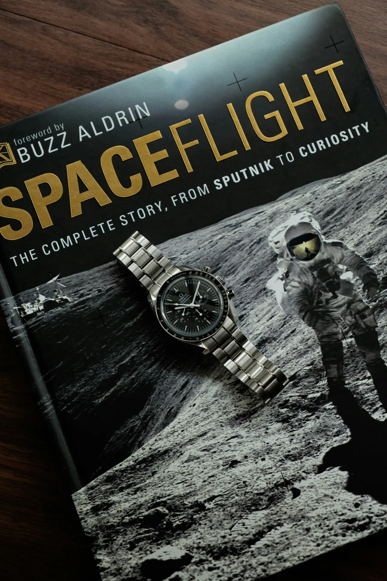 Omega Speedmaster Professional resting on a Spaceflight book — the Moonwatch legacy