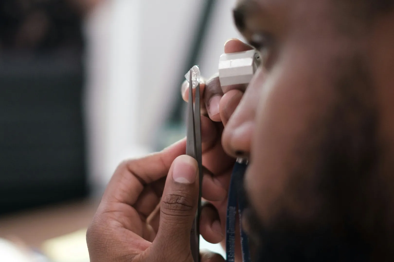 Gemologist examining a diamond through a jeweler's loupe for authentication