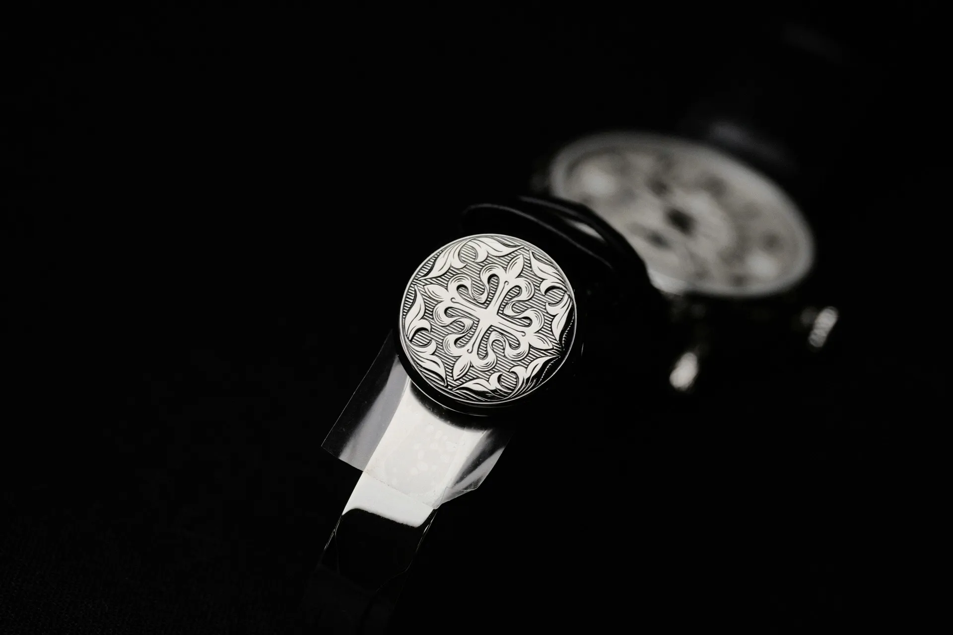 Close-up of Patek Philippe engraved crown showing the Calatrava cross motif