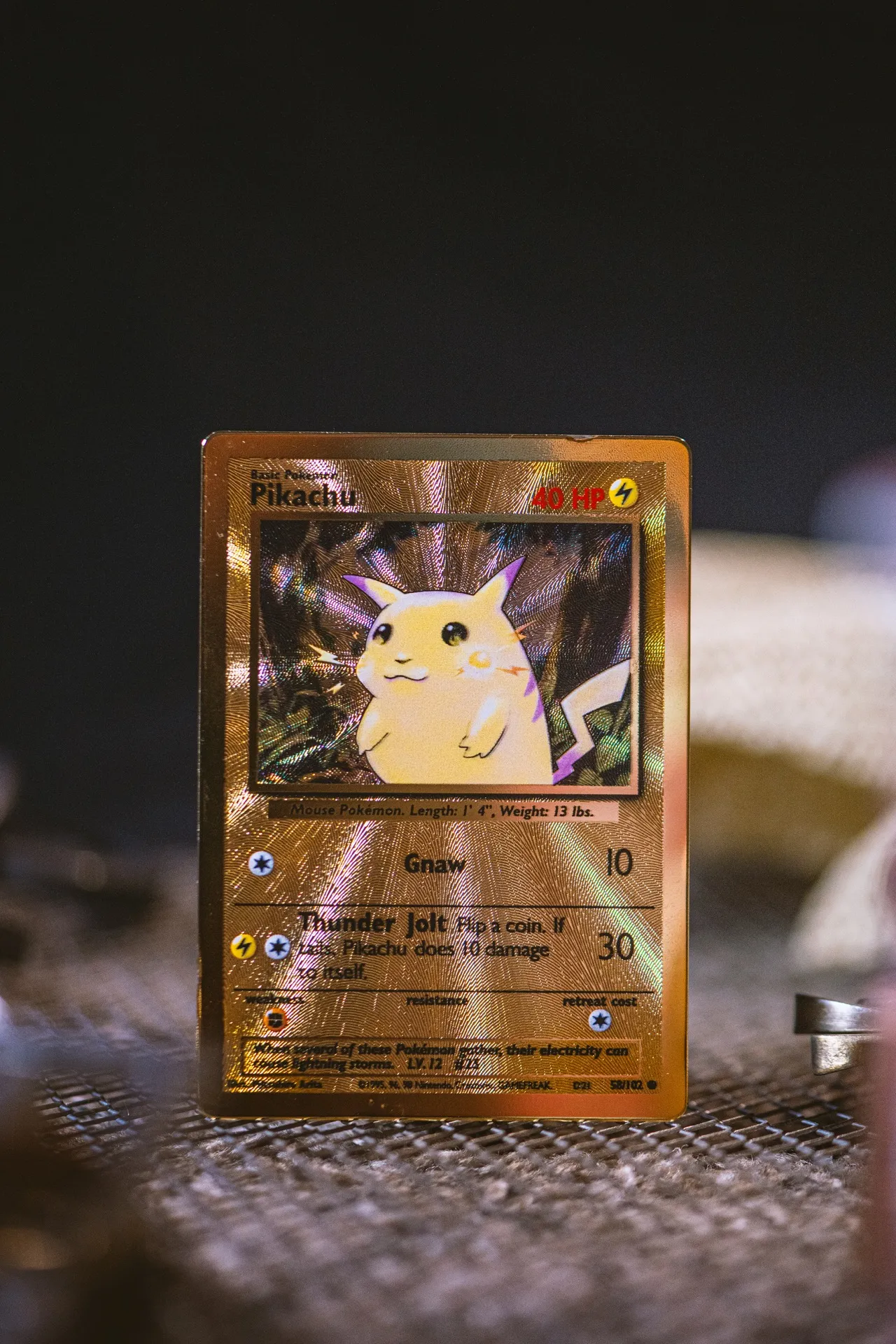 Holographic Pikachu Pokemon trading card standing upright against dark background