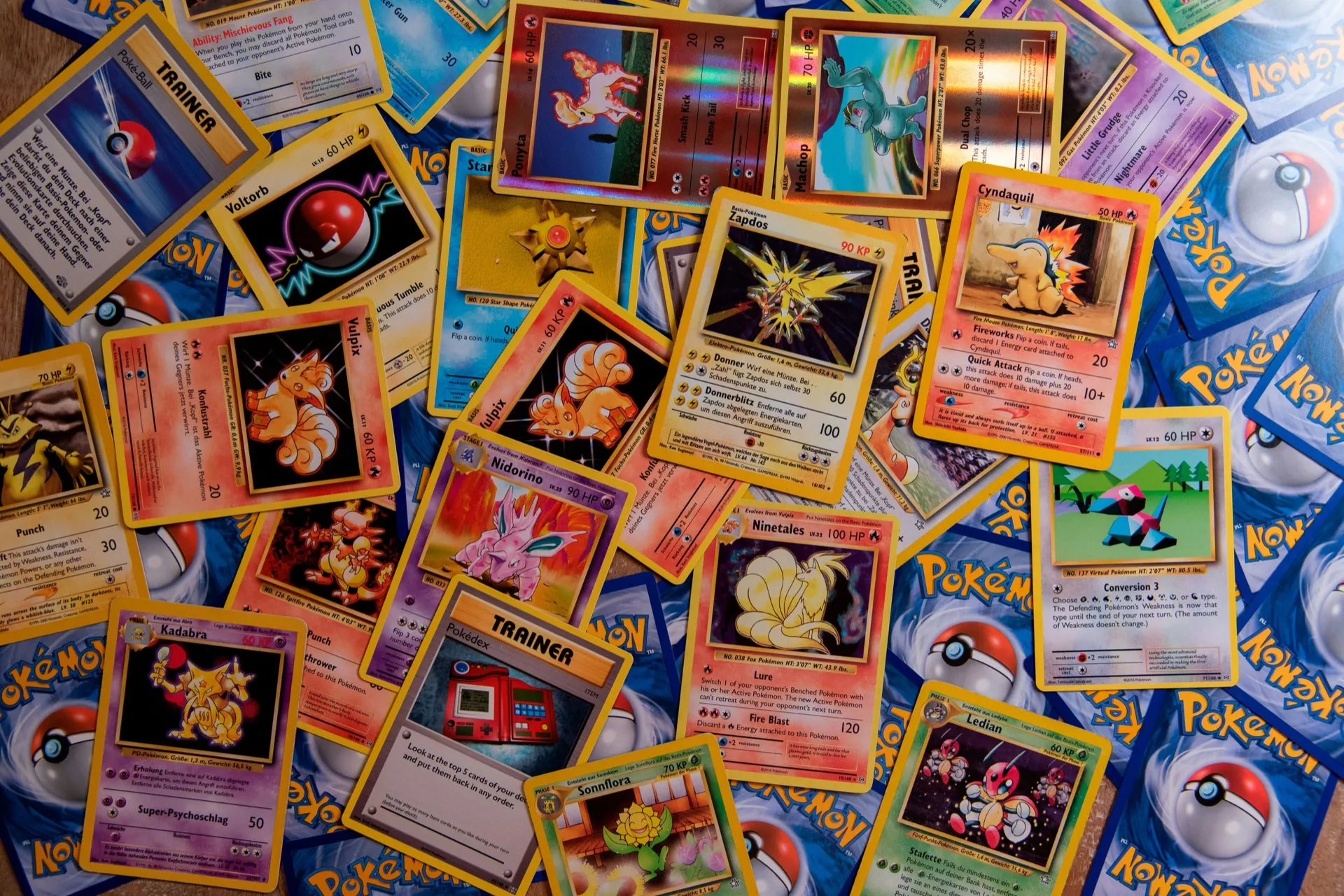 Spread of vintage first-generation Pokemon trading cards face-up on a table