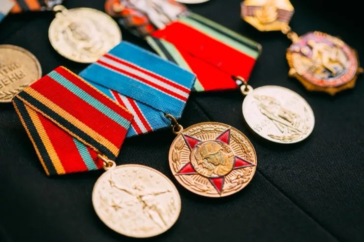Collection of Soviet-era military anniversary medals with colorful ribbons on dark fabric